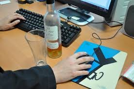 Main sur souris, vin et bureau d’ordinateur