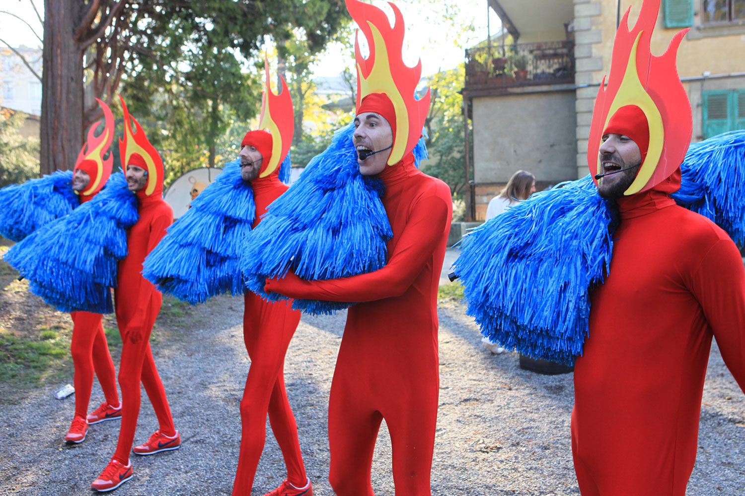 Artistes en costumes rouges avec flammes et pompons bleus