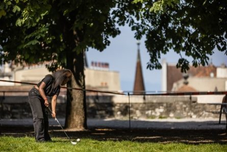 Personne jouant au golf dans un parc urbain