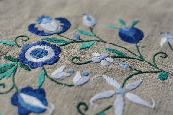 Broderie florale bleue et blanche sur tissu beige