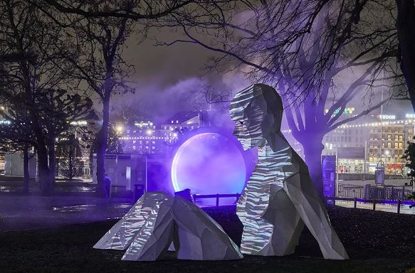 Sculpture humaine géométrique illuminée dans un parc nocturne