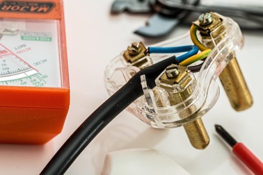 Prise électrique ouverte avec fils et multimètre